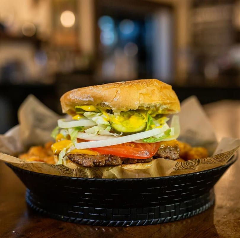 Juicy double cheeseburger with fresh toppings and cheese, served in a basket with fries.